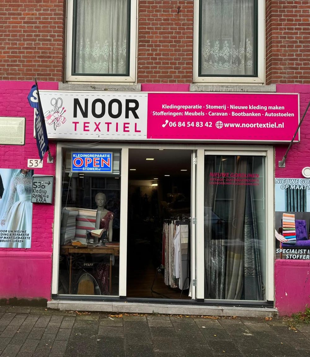 De roze gevel van Noor Textiel aan de Van der Palmstraat